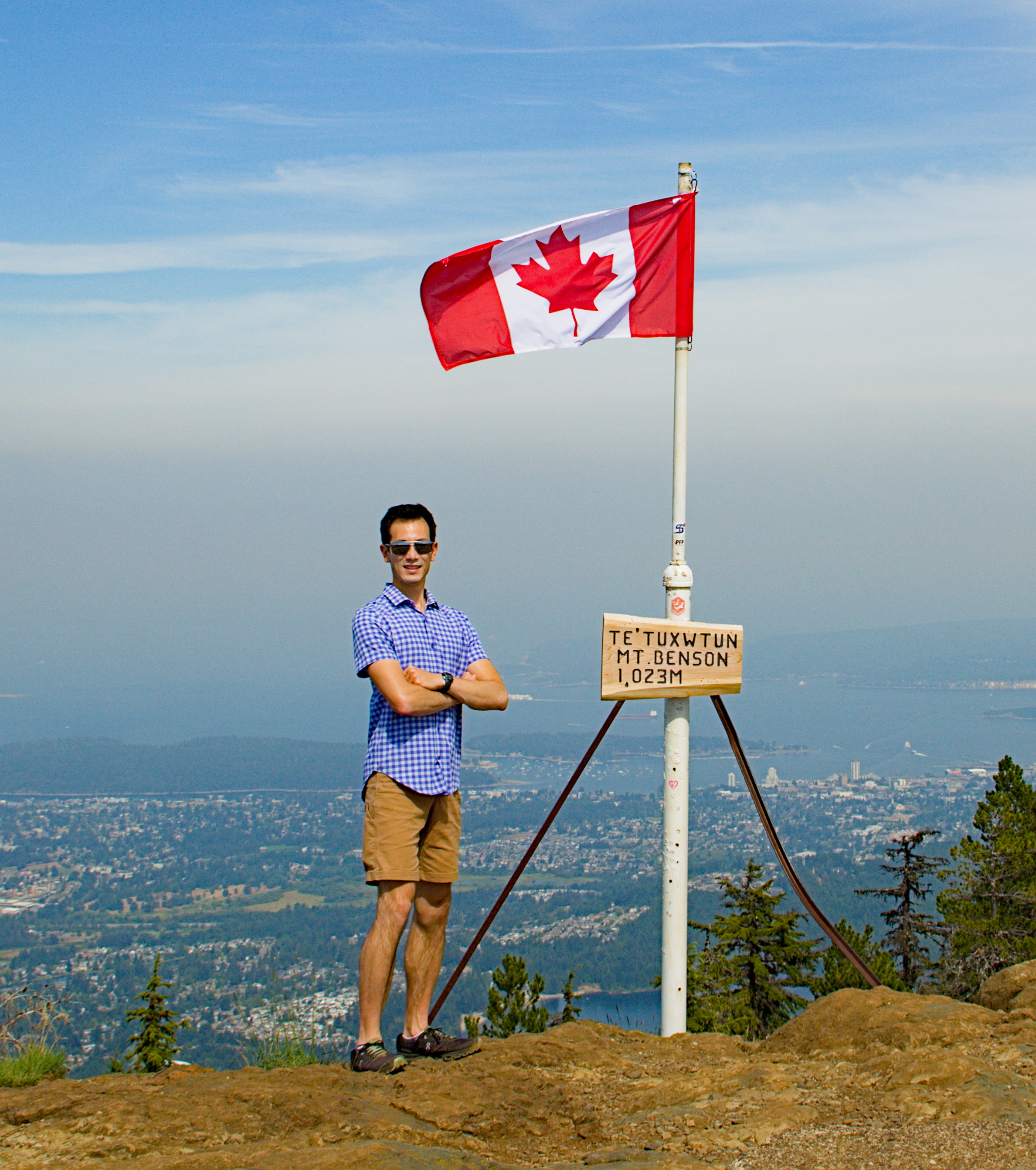 Matthew next to the Canadian flag on Mt. Benson
